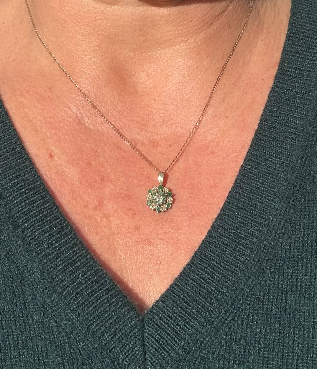 Emerald and diamond pendant on a gold chain