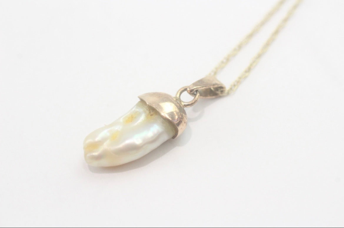 Dogtooth pearl pendant on a gold chain
