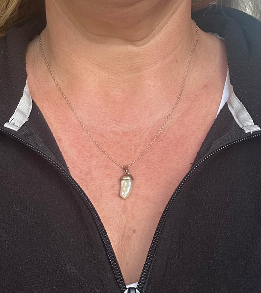 Dogtooth pearl pendant on a gold chain
